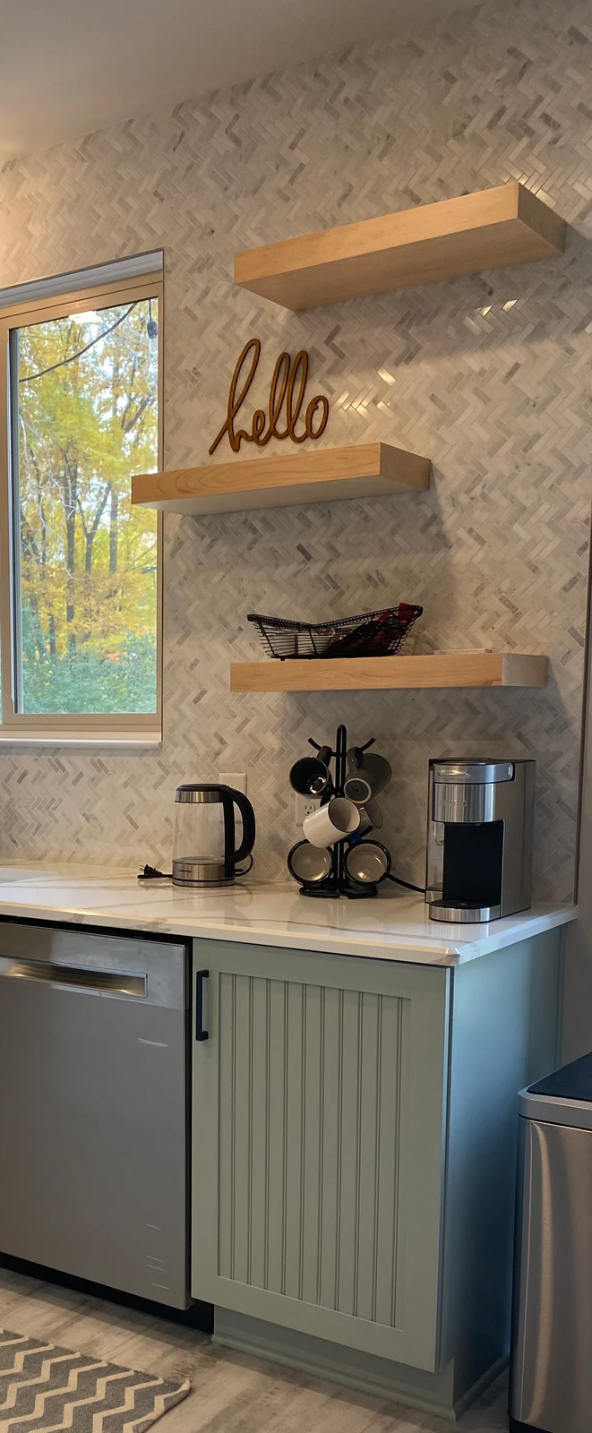 A considered kitchen detail with cabinetry, natural wood and open shelving.